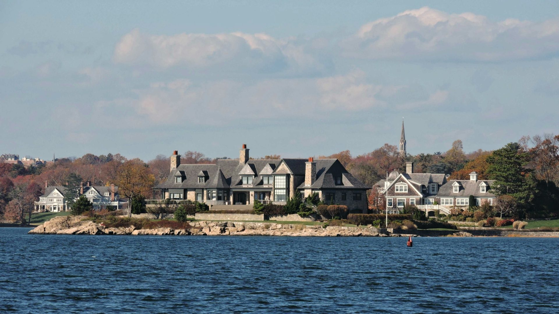 Large waterfront houses on a sunny day.